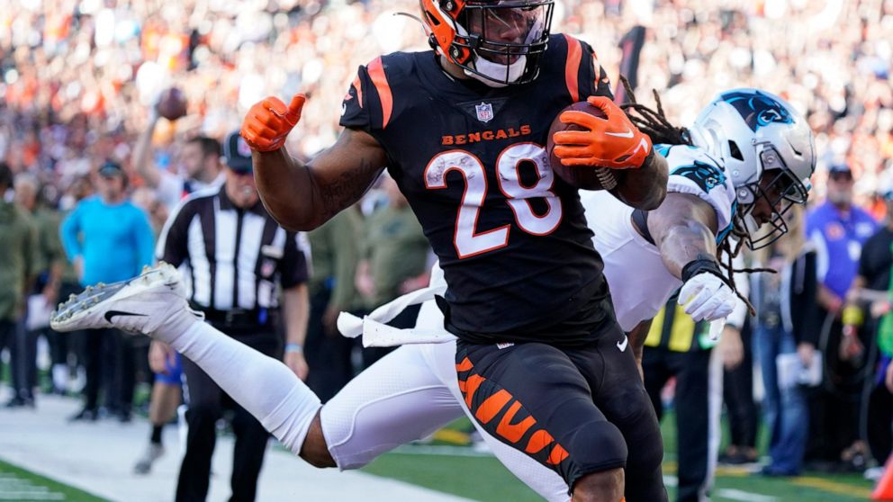 Cincinnati Bengals running back Joe Mixon (28) runs past Carolina Panthers linebacker Shaq Thompson, right, for a touchdown during the second half of an NFL football game, Sunday, Nov. 6, 2022, in Cincinnati. (AP Photo/Joshua A. Bickel)