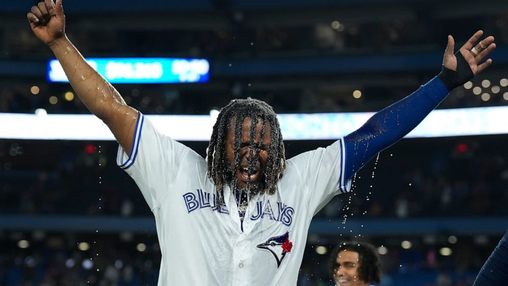 Toronto Blue Jays' Vladimir Guerrero Jr. raises his arms after being doused following the team's win over the Baltimore Orioles in 10 innings in a baseball game Wednesday, June 15, 2022, in Toronto. Guerrero drove in the winning run. (Nathan Denette/
