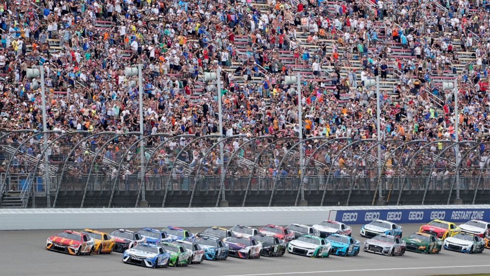 Bubba Wallace (23) leads the field to the start during an NASCAR Cup Series auto race at the Michigan International Speedway in Brooklyn, Mich., Sunday, Aug. 7, 2022. (AP Photo/Paul Sancya)