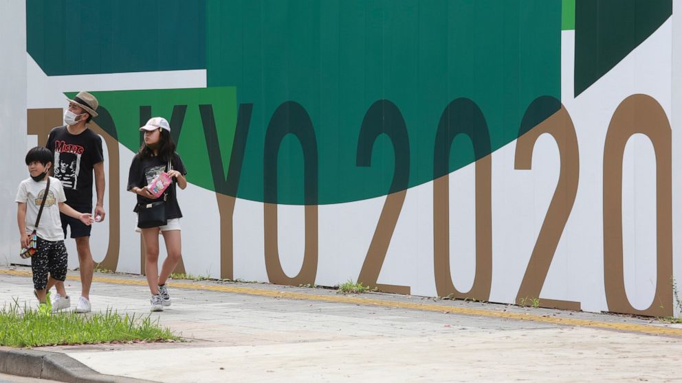 People walk by posters to promote Tokyo 2020 Olympics in Tokyo, Wednesday, July 14, 2021. The Olympic Games are scheduled to begin on July 23. (AP Photo/Koji Sasahara)