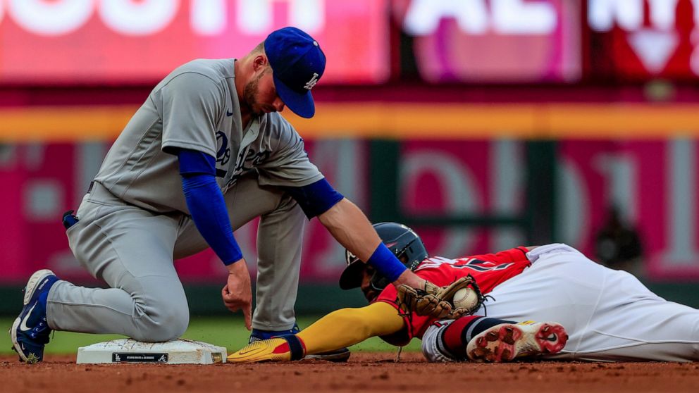 Atlanta Braves' Ronald Acuna Jr., right, is tagged out by Los Angeles Dodgers second baseman Gavin Lux, left, as he slides into second during the first inning of a baseball game Friday, June 24, 2022, in Atlanta. (AP Photo/Butch Dill)