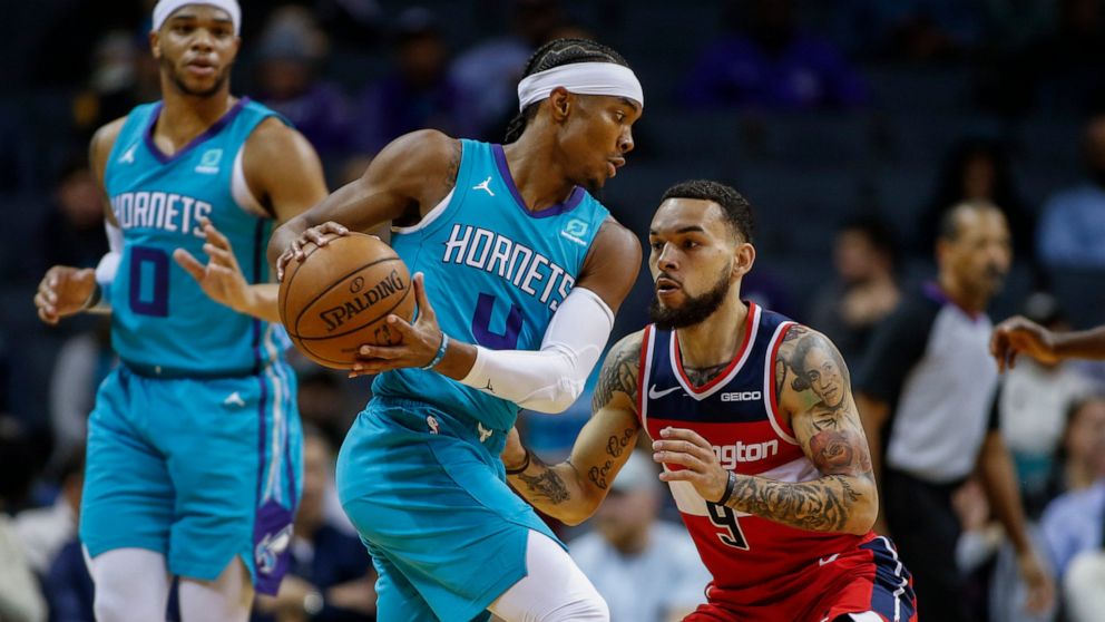 Charlotte Hornets guard Devonte' Graham, left, looks for room to drive against Washington Wizards guard Chris Chiozza in the first half of an NBA basketball game in Charlotte, N.C., Tuesday, Dec. 10, 2019. (AP Photo/Nell Redmond)