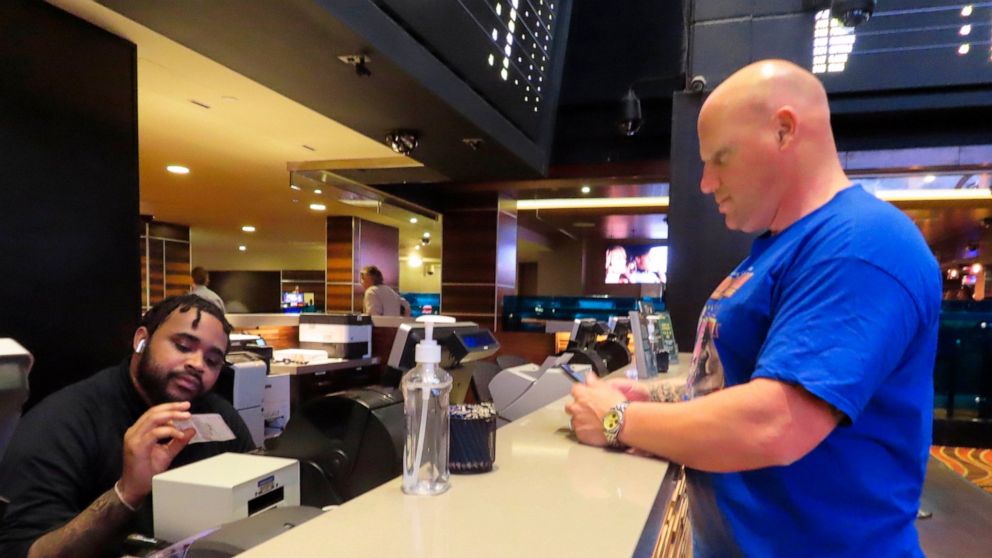 A customer cashes a winning ticket on a New York Mets baseball game in the sports betting lounge at the Tropicana casino in Atlantic City N.J. on Thursday, May 12, 2022. American gamblers have wagered over $125 billion on sports with legal betting ou