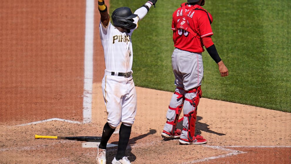 Pittsburgh Pirates' Rodolfo Castro, left, celebrates as teammate Ke'Bryan Hayes (not shown) beats out a fielder's choice, allowing Castro to score from third, during the eighth inning of a baseball game against the Cincinnati Reds in Pittsburgh, Sund