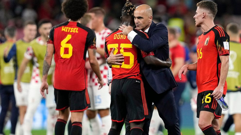 Belgium's head coach Roberto Martinez embraces Belgium's Jeremy Doku after their team was defeated at the World Cup group F soccer match between Croatia and Belgium at the Ahmad Bin Ali Stadium in Al Rayyan, Qatar, Thursday, Dec. 1, 2022. (AP Photo/T