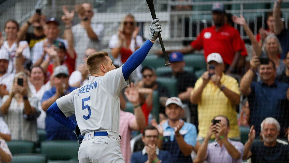 Los Angeles Dodgers' Freddie Freeman reacts to a standing ovation as he takes his first at-bat during the first inning of a baseball game against the Atlanta Braves, Sunday, June 26, 2022, in Atlanta. (AP Photo/Bob Andres)