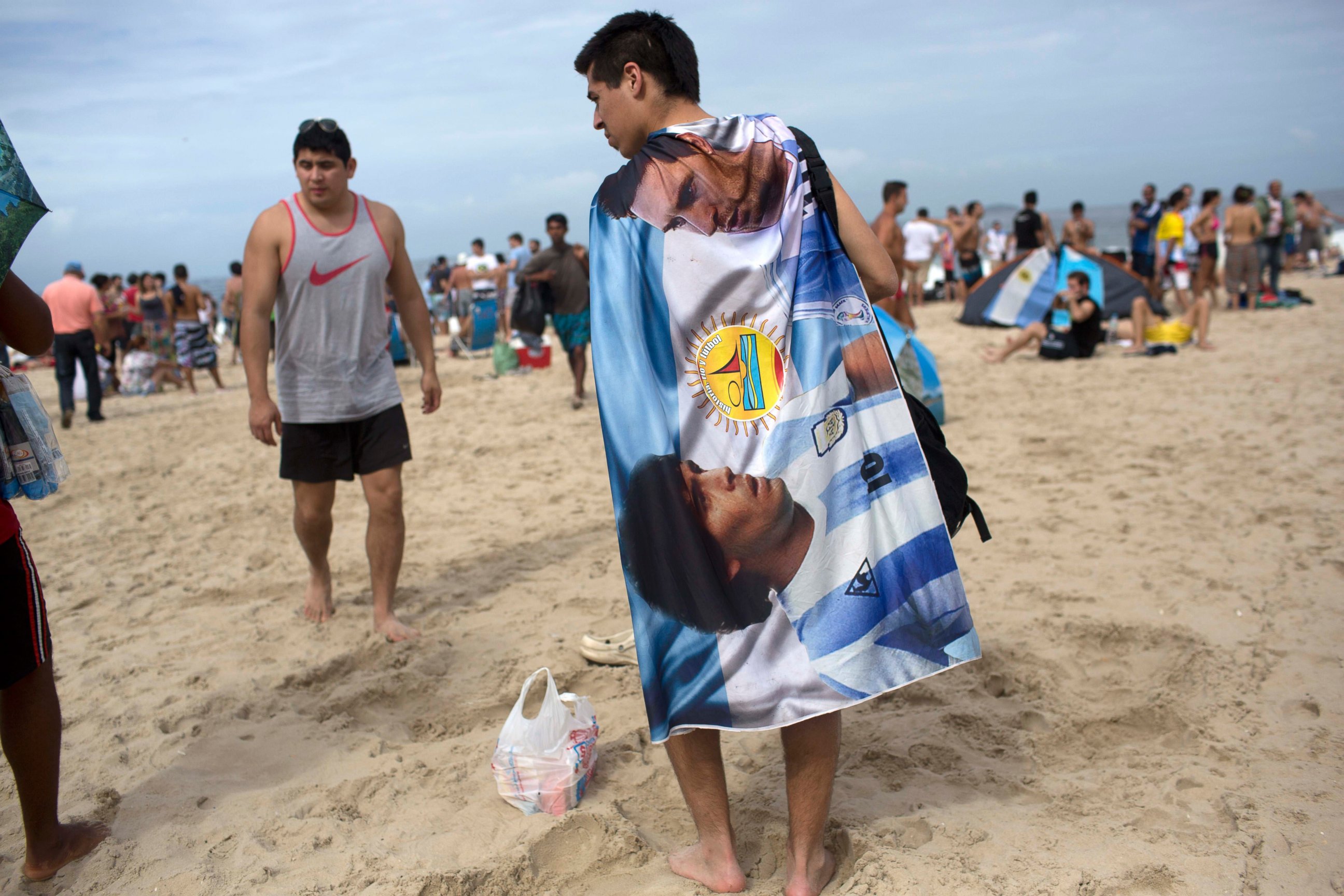 PHOTO: A soccer fan wears a banner designed with images of Diego Maradona and Lionel Messi, on Copacabana Beach in Rio de Janeiro, Brazil, July 12, 2014. 
