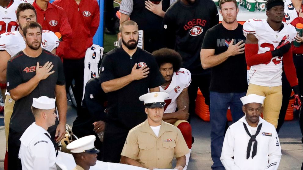 PHOTO: San Francisco 49ers quarterback Colin Kaepernick, middle, sits during the national anthem before the team's NFL preseason football game against the San Diego Chargers, Sept. 1, 2016, in San Diego.