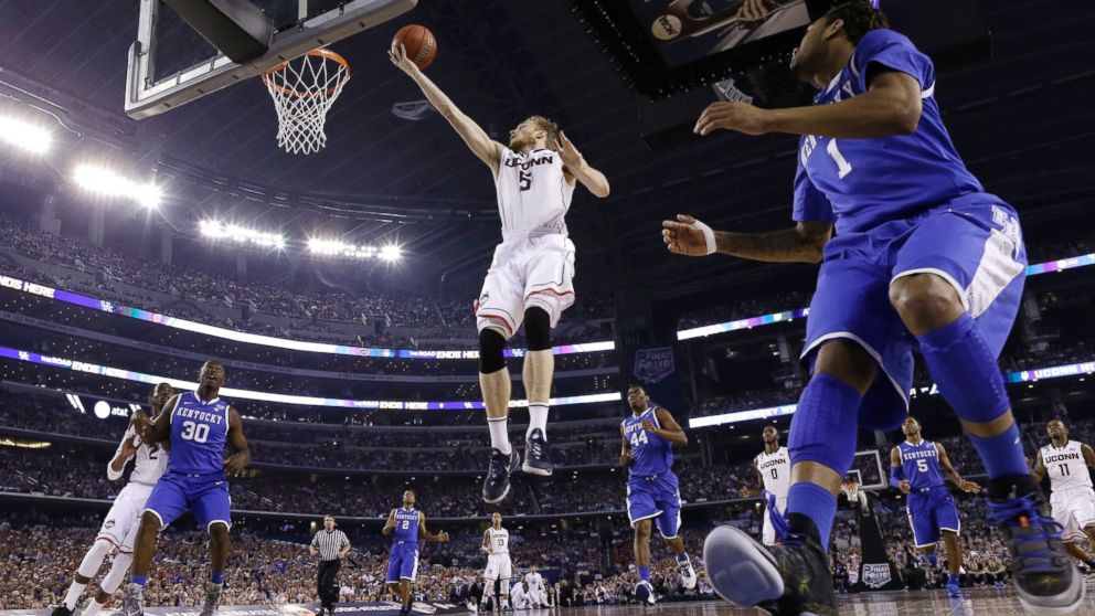 Connecticut guard Niels Giffey (5) drives to the basket in front of Kentucky guard James Young, right, during the first half of the NCAA Final Four tournament college basketball championship game Monday, April 7, 2014, in Arlington, Texas.