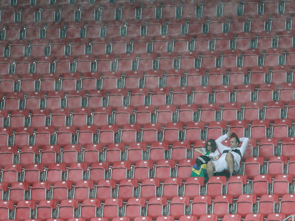 PHOTO: Visitors sit on the tribune as rain pours down prior to the group G World Cup soccer match between the USA and Germany at the Arena Pernambuco in Recife, Brazil, June 26, 2014.