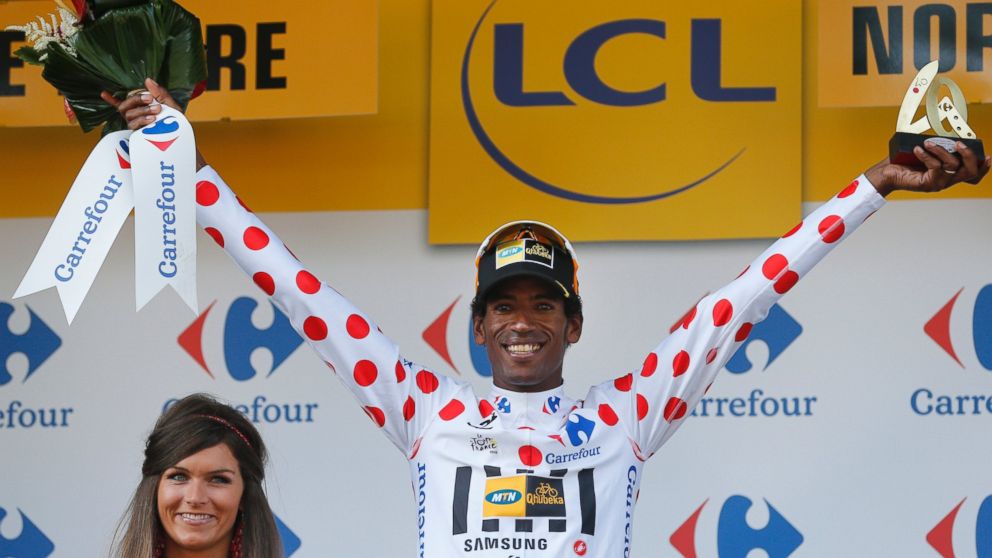 Daniel Teklehaimanot, wearing the best climber's dotted jersey, celebrates on the podium of the sixth stage of the Tour de France cycling race over 191.5 kilometers (119 miles) with start in Abbeville and finish in Le Havre, France, July 9, 2015. 