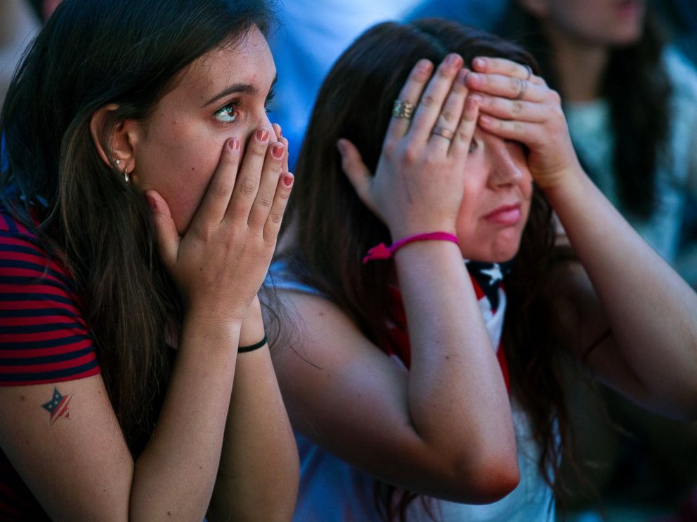 PHOTO: Allison DiFilippo, left, and Samantha Donat, both of New York, react to a last-minute goal at the end of their 2014 World Cup Group G soccer match, while watching a large screen broadcast on Governors Island in New York, June 22, 2014.