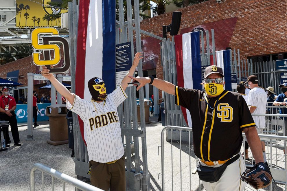 PHOTO: Baseball fans Mercury Hornbeek and Steven Ames wait in line before the gates opened up before a baseball game between the Arizona Diamondbacks and the San Diego Padres in San Diego, April 1, 2021.