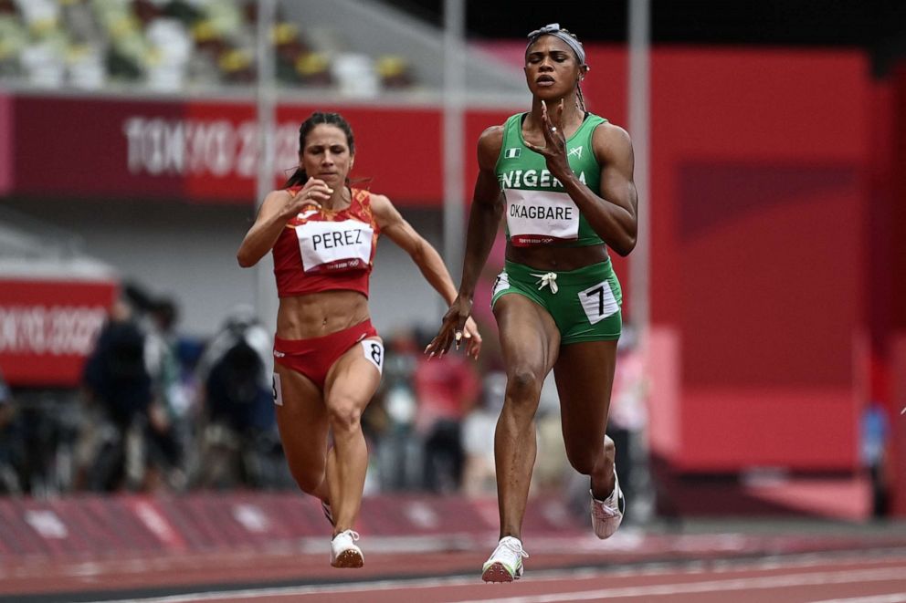 PHOTO: Nigeria's Blessing Okagbare and Spain's Maria Isabel Perez compete in the women's 100m heats during the Tokyo 2020 Olympic Games at the Olympic Stadium in Tokyo, July 30, 2021.