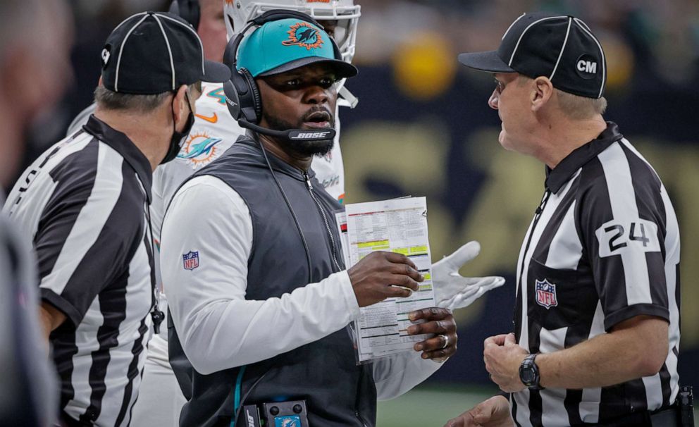 PHOTO: Miami Dolphins head coach Brian Flores, center, talks to down judge David Oliver during the first half of an NFL football game against the New Orleans Saints Monday, Dec. 27, 2021, in New Orleans.