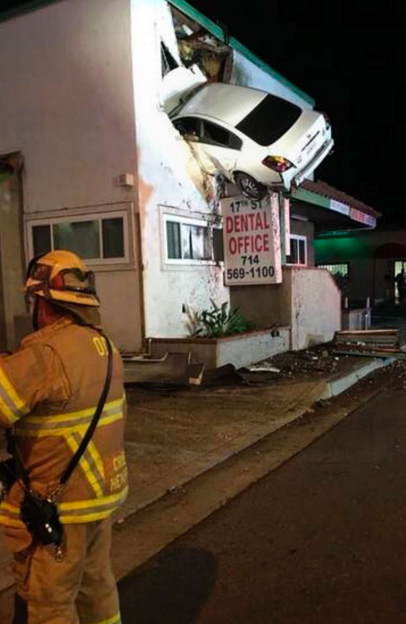 PHOTO: A vehicle that crashed into a building hangs from a second story window in Santa Ana, Calif., Jan. 14, 2018.  Two people in the car escaped serious injuries after the car went airborne and slammed into the second floor of a dental office.
