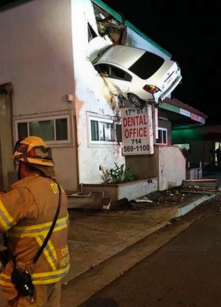 PHOTO: A vehicle that crashed into a building hangs from a second story window in Santa Ana, Calif., Jan. 14, 2018.  Two people in the car escaped serious injuries after the car went airborne and slammed into the second floor of a dental office.