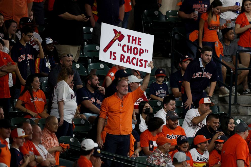 PHOTO: A fan holds a sign stating "the chop is racist" during the ninth inning in Game One of the World Series during the ninth inning at Minute Maid Park on Oct. 26, 2021, in Houston.