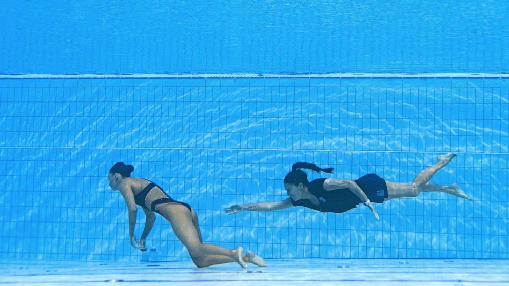 PHOTO: A member of Team USA swims to recover USA's Anita Alvarez, from the bottom of the pool during an incident in the women's solo free artistic swimming finals, during the Budapest 2022 World Aquatics Championships in Budapest on June 22, 2022.