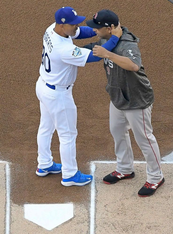 PHOTO: Los Angeles Dodgers manager Dave Roberts and Boston Red Sox manager Alex Cora hug before Game 3 of the World Series baseball game on Friday, Oct. 26, 2018, in Los Angeles. 