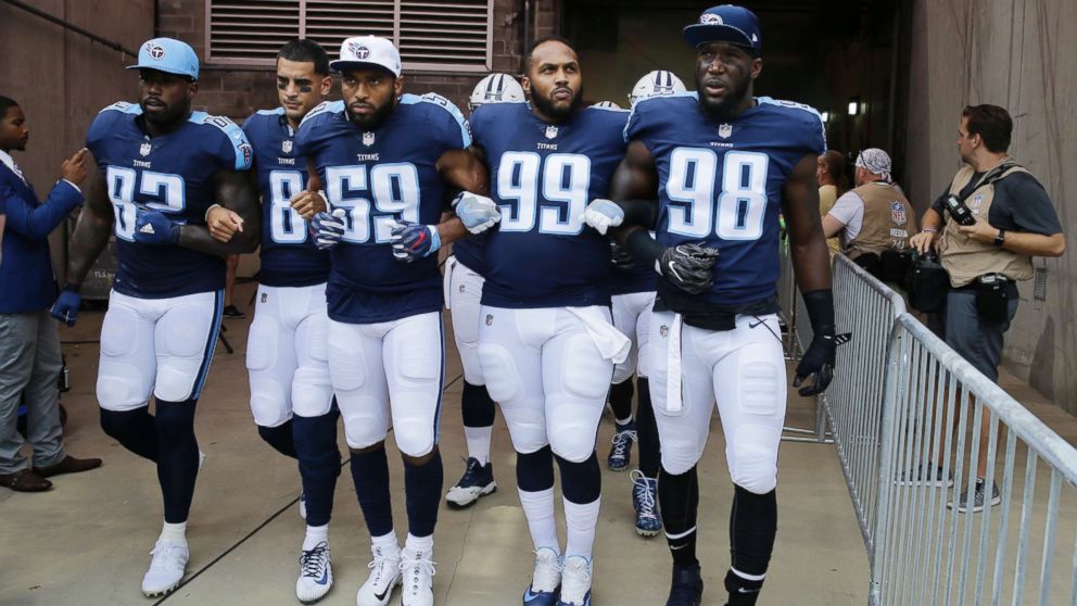 Tennessee Titans' Delanie Walker (82), Marcus Mariota (8), Wesley Woodyard (59), Jurrell Casey (99) and Brian Orakpo (98) walk to the field with arms linked after the national anthem had been played before an NFL football game against the Seattle Seahawks in Nashville, Tenn., Sept. 24, 2017. 