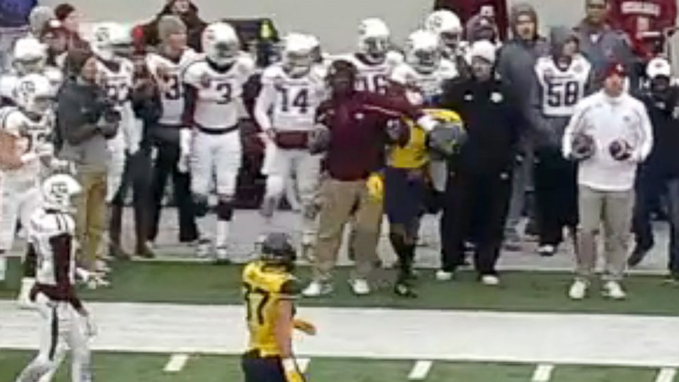 A member of the Texas A&M sideline crew was filmed shoving two West Virginia players during the AutoZone Liberty Bowl on Dec. 29, 2014.