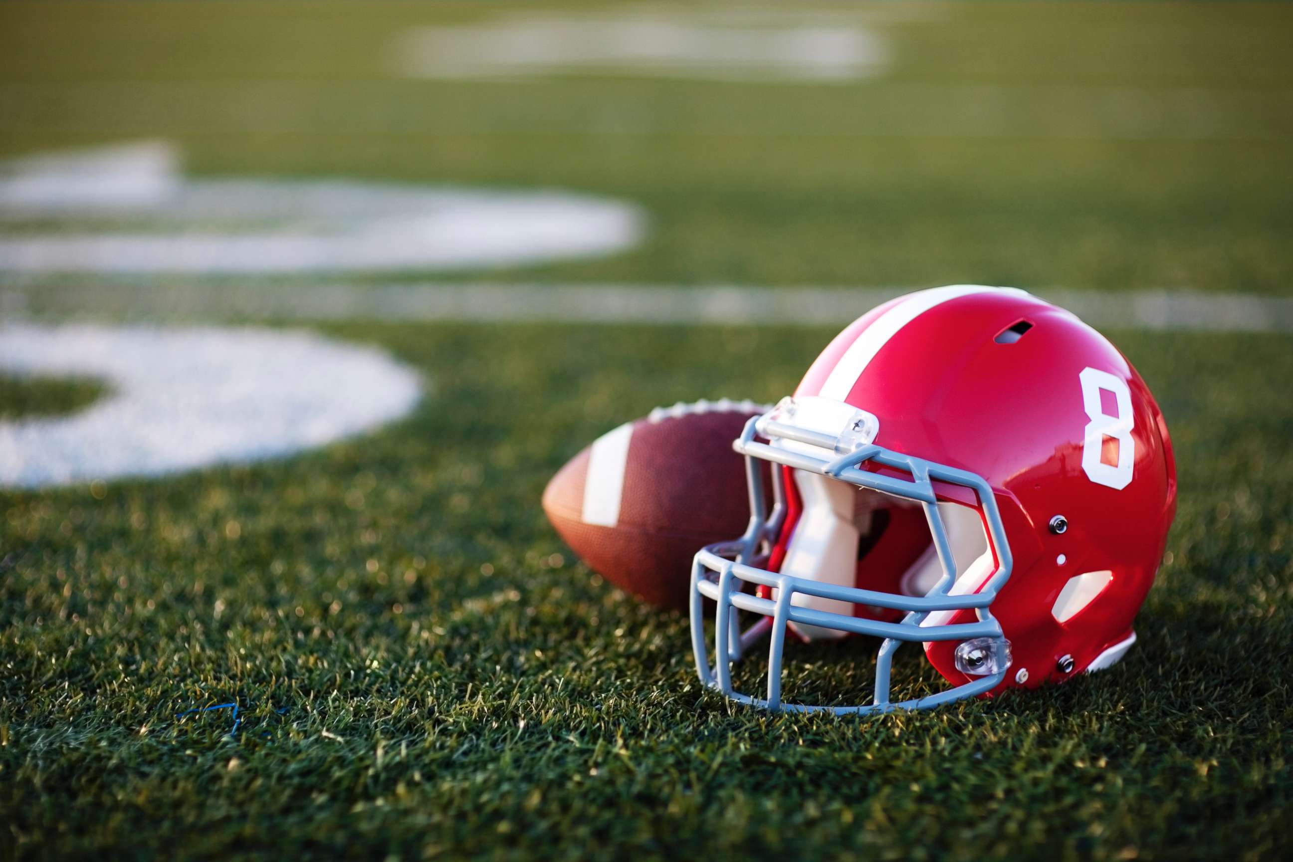 PHOTO: Football and helmet on a field.
