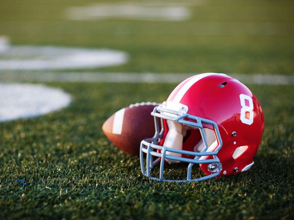 PHOTO: Football and helmet on a field.