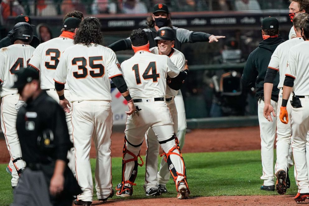 PHOTO: San Francisco Giants catcher Chadwick Tromp  hugs right fielder Mike Yastrzemski after hitting a walk off home run to win the game against the San Diego Padres at Oracle Park, July 29, 2020.