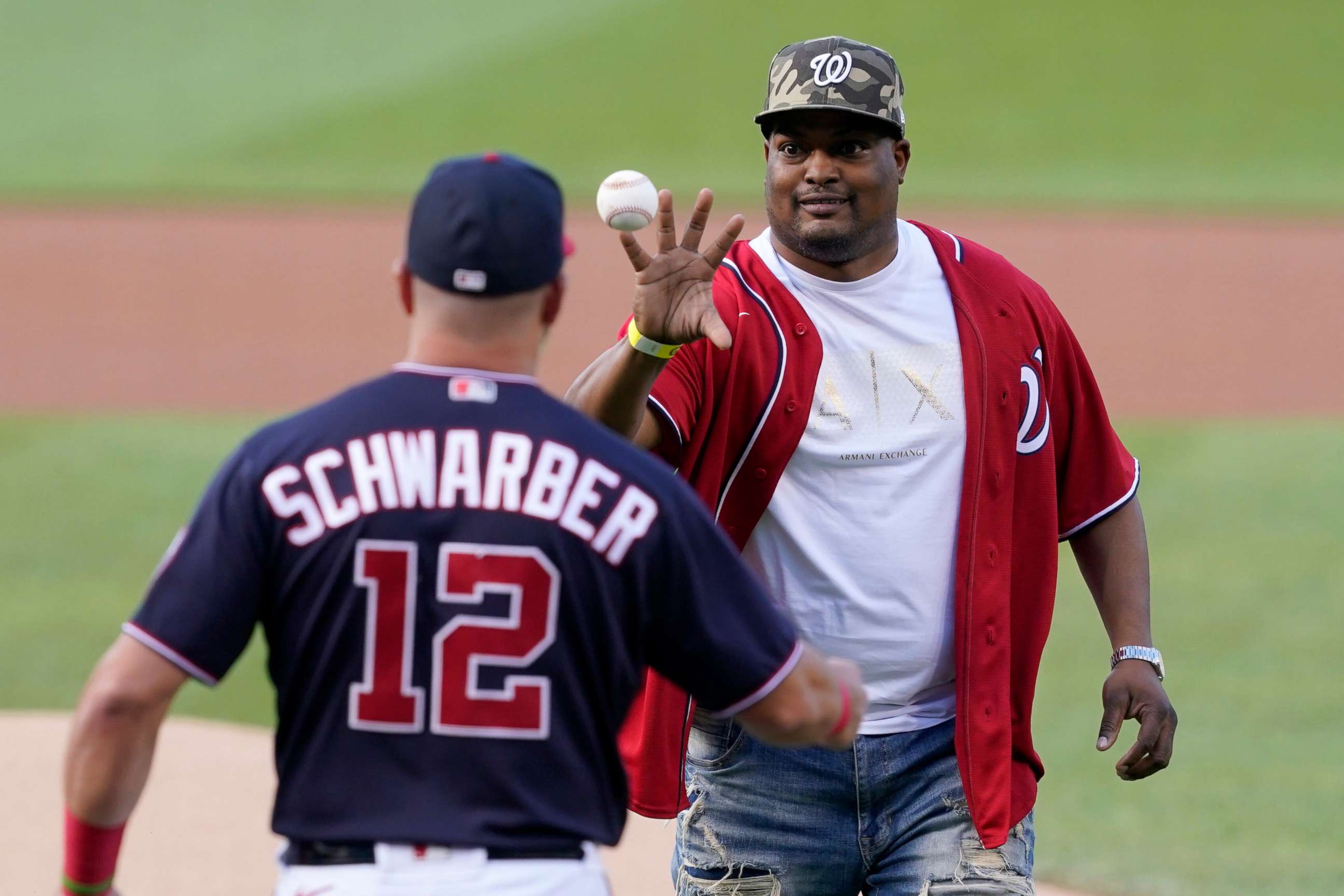 PHOTO: U.S. Capitol Police officer Eugene Goodman catches the ball from Washington Nationals' Kyle Schwarber after throwing out the first pitch before the Washington Nationals baseball game against the New York Mets, Friday, June 18, 2021, in Washington.