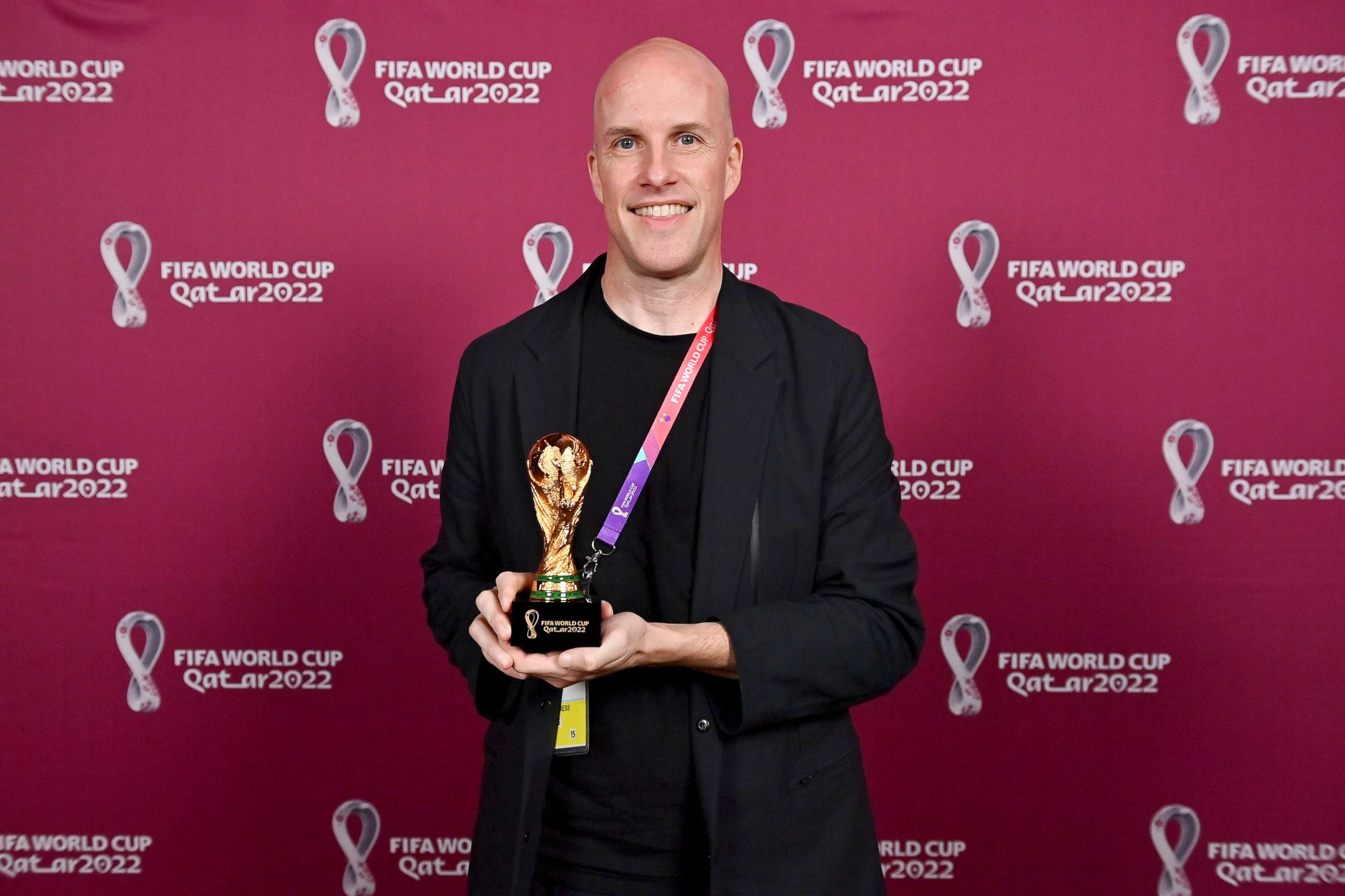 PHOTO: Grant Wahl smiles as he holds a World Cup replica trophy during an award ceremony in Doha, Qatar on Nov. 29, 2022.