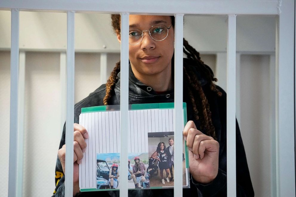 PHOTO: Brittney Griner holds images standing in a cage at a court room prior to a hearing, in Khimki just outside Moscow, July 26, 2022.