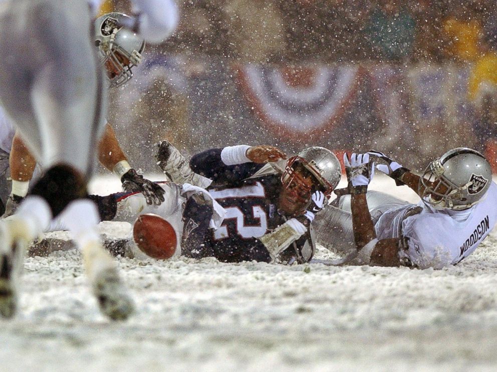 PHOTO: Patriots quarterback Tom Brady loses the ball after being hit by the Oakland Raiders Charles Woodson, right, Jan. 19, 2002.
