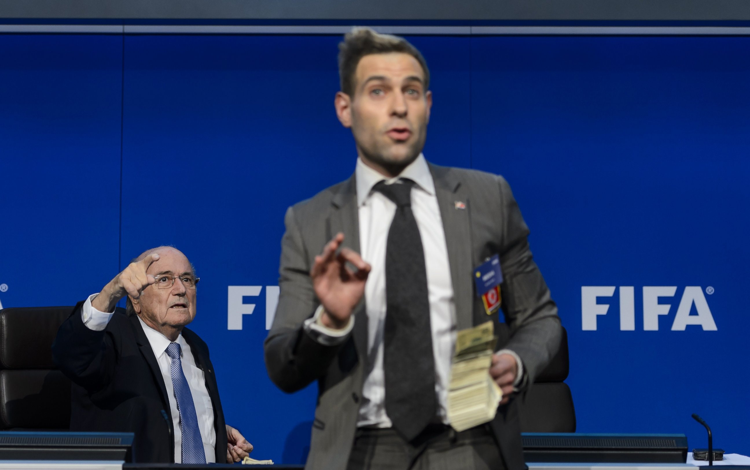 PHOTO: Comedian Simon Brodkin gestures in front of FIFA president Sepp Blatter during a press conference at the football's world body headquarter's on July 20, 2015 in Zurich.