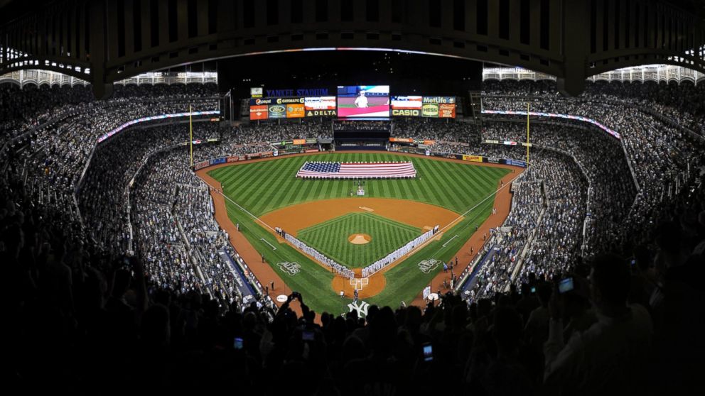 The New York Yankees and the Detroit Tigers stand at attention during the National Anthem before Game One of the American League Division Series at Yankee Stadium, Sept. 30, 2011 in the Bronx borough of New York City. 