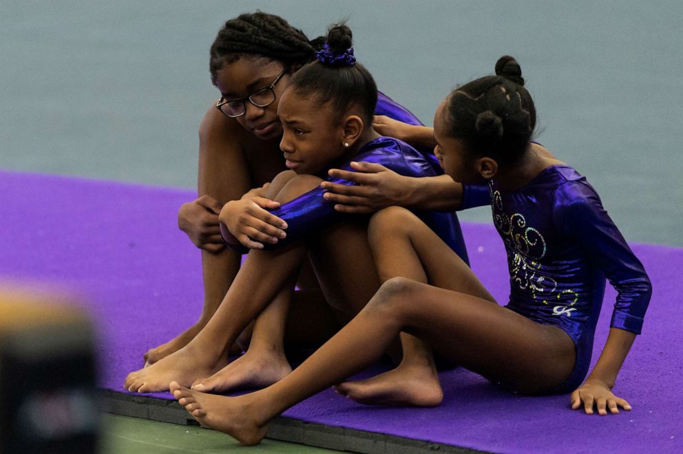 PHOTO: Gymnasts Comora Johnson, Rielle Taitt-Lance and Londyn Morris embrace during The Harlem Gymnastics Invitational competition at the Wendy Hilliard Gymnastics Foundation in New York, Feb. 22, 2020.