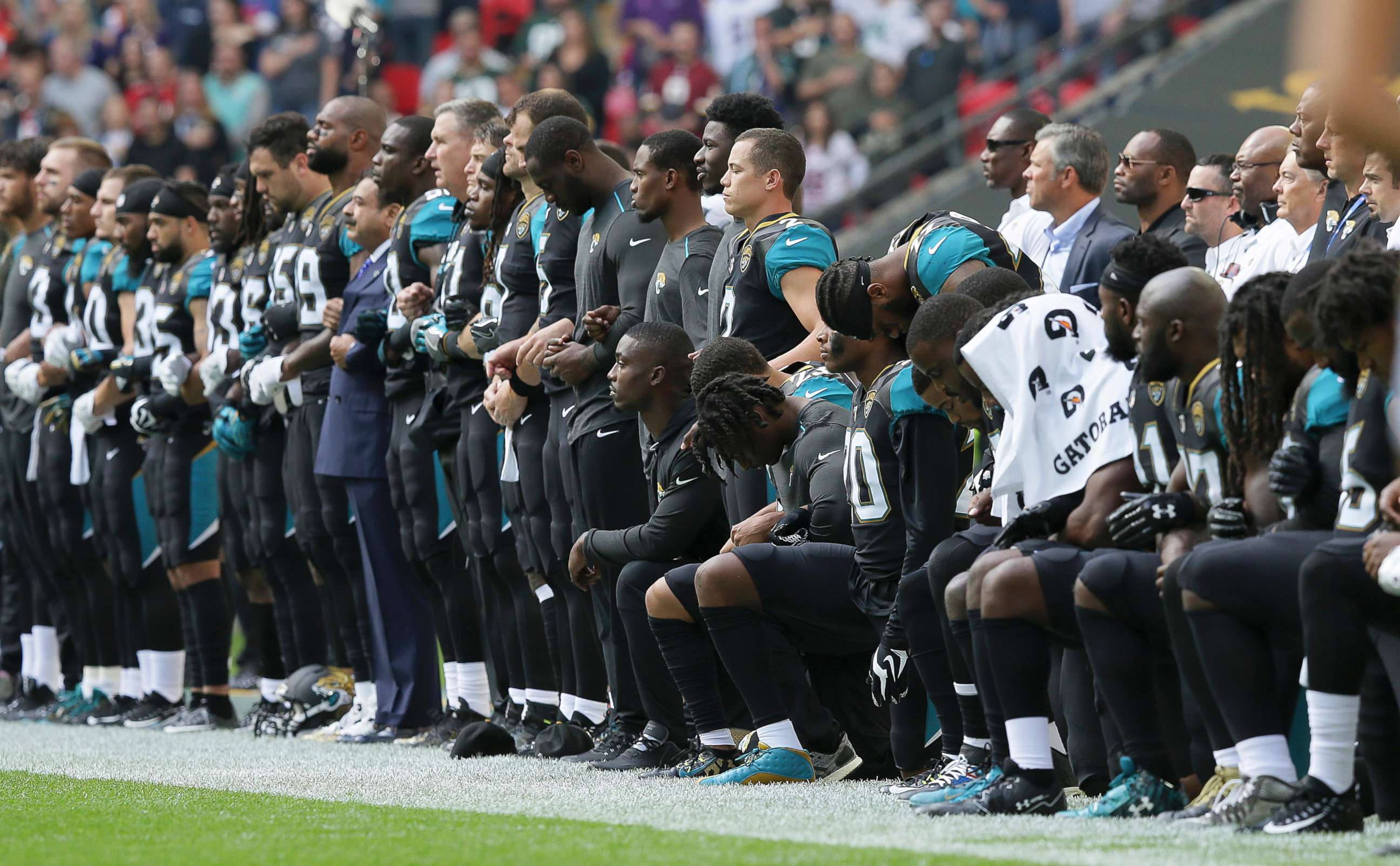 PHOTO: Jacksonville Jaguars players lock arms and kneel down during the playing of the U.S. national anthem before an NFL football game against the Baltimore Ravens at Wembley Stadium in London, Sept. 24, 2017. 