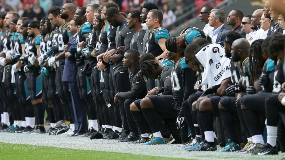 PHOTO: Jacksonville Jaguars players lock arms and kneel down during the playing of the U.S. national anthem before an NFL football game against the Baltimore Ravens at Wembley Stadium in London, Sept. 24, 2017. 