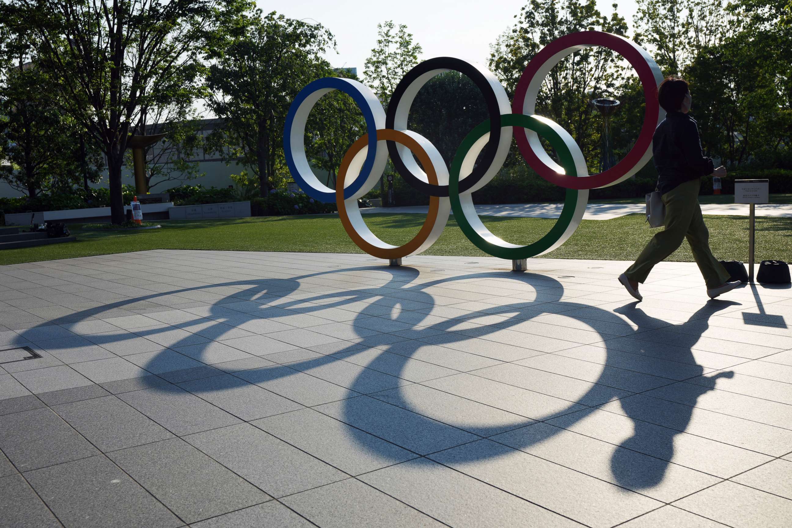PHOTO: A woman walks by the Olympic Rings near the National Stadium in Tokyo Wednesday, June 9, 2021.