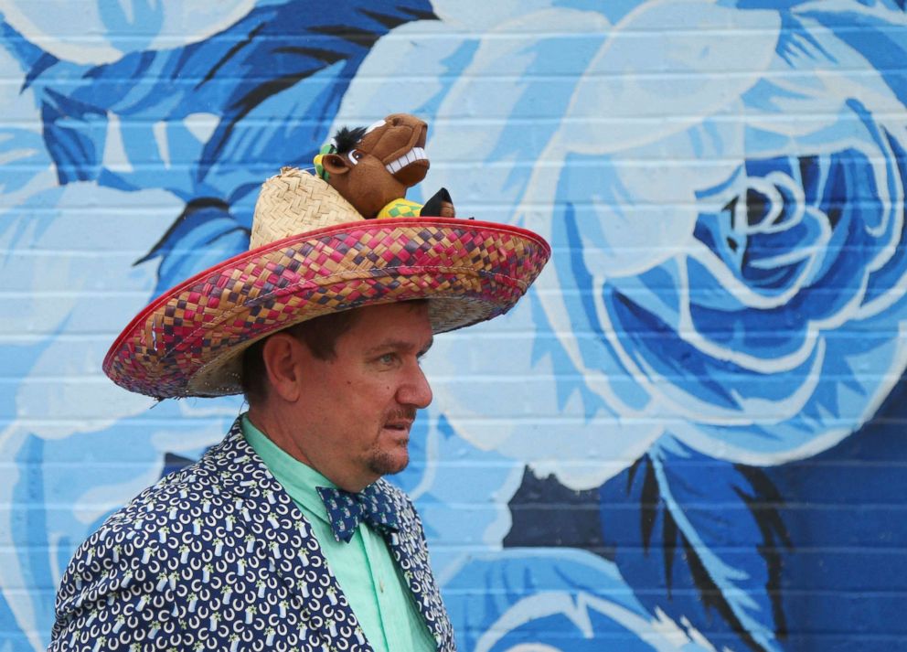 PHOTO: A man walks past a mural in his Cinco de Mayo themed derby hat during the 144th running of the Kentucky Derby at Churchill Downs, May 5, 2018 in Louisville, Ky.