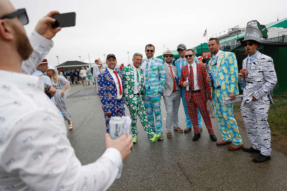 PHOTO: Men wear colorful suits in the infield before the 144th running of the Kentucky Derby horse race at Churchill Downs, May 5, 2018, in Louisville, Ky.