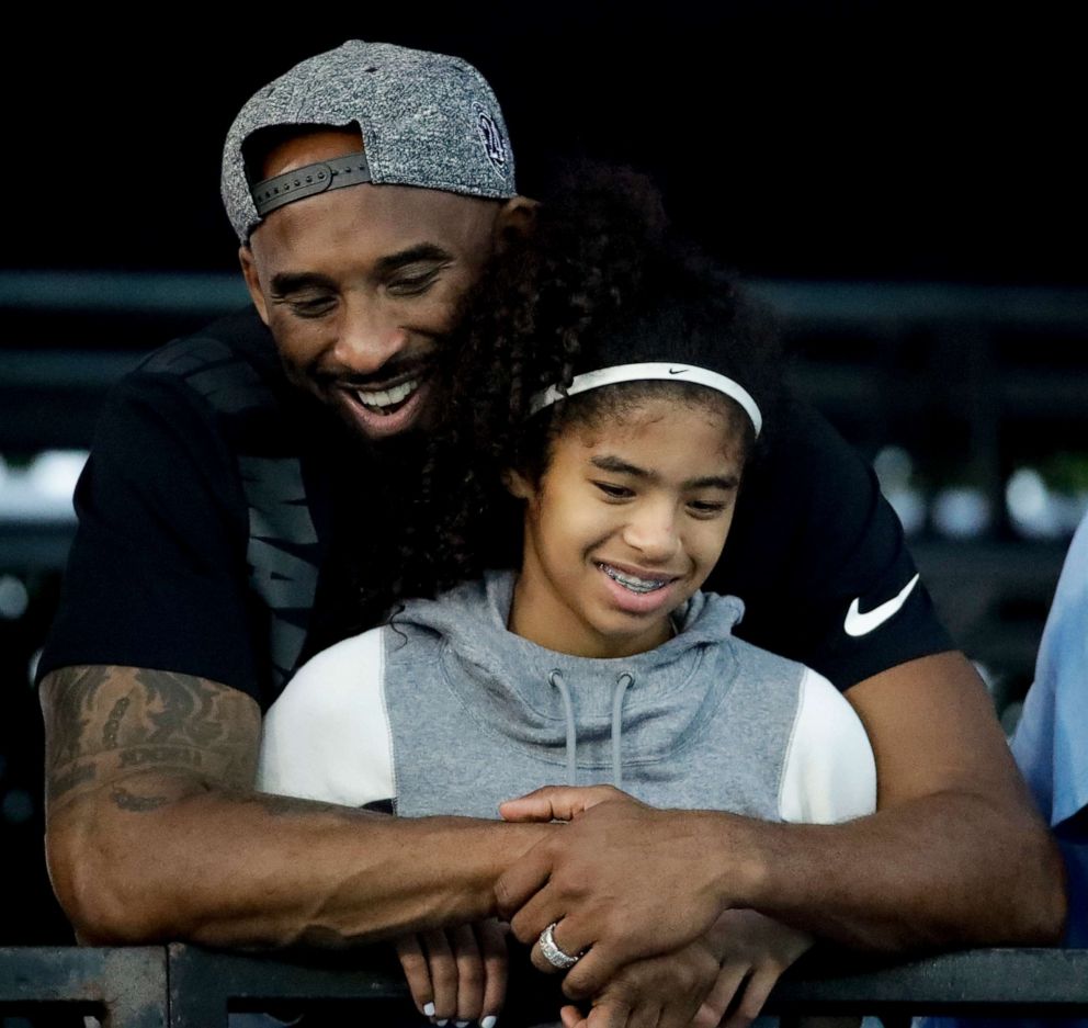 PHOTO: In this file photo taken on July 26, 2018, retired NBA star Kobe Bryant and his daughter Gianna watch during the U.S. national championships swimming meet in Irvine, California.