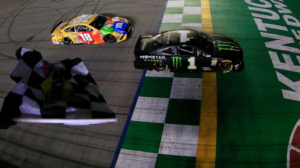 PHOTO: In this July 13, 2019, file photo, Kurt Busch, driver of the #1 Monster Energy Chevrolet, takes the checkered flag ahead of Kyle Busch, driver of the #18 M&M's Toyota Camry Toyota, to win the Monster Energy NASCAR Cup Series Quaker State 400.