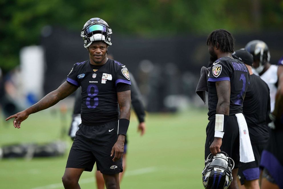PHOTO: Baltimore Ravens quarterback Lamar Jackson, left, gestures to quarterback Tyler Huntley during an NFL football practice, Aug. 16, 2021, in Owings Mills, Md.