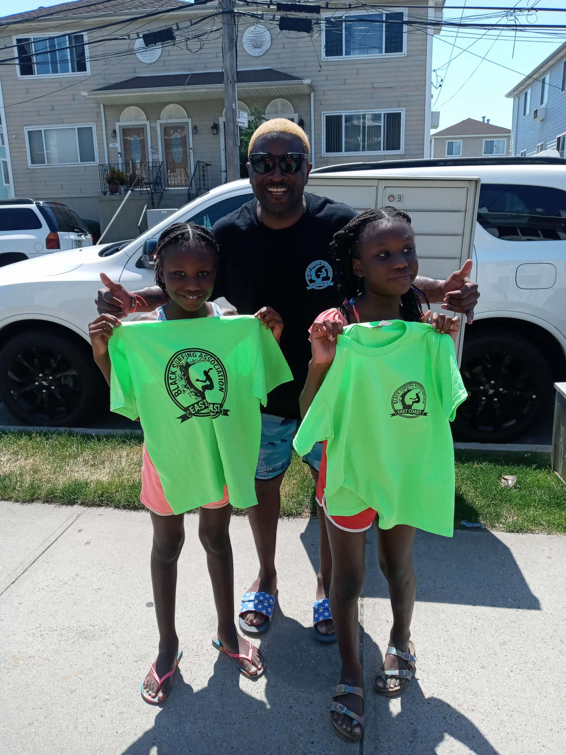 PHOTO: Lou Harris, the founder of the East Coast chapter of the Black Surfing Association, poses for a photo with twins Nyla and Soleil Landau. Harris provides free surfing lessons to youths in New York's Rockaways.