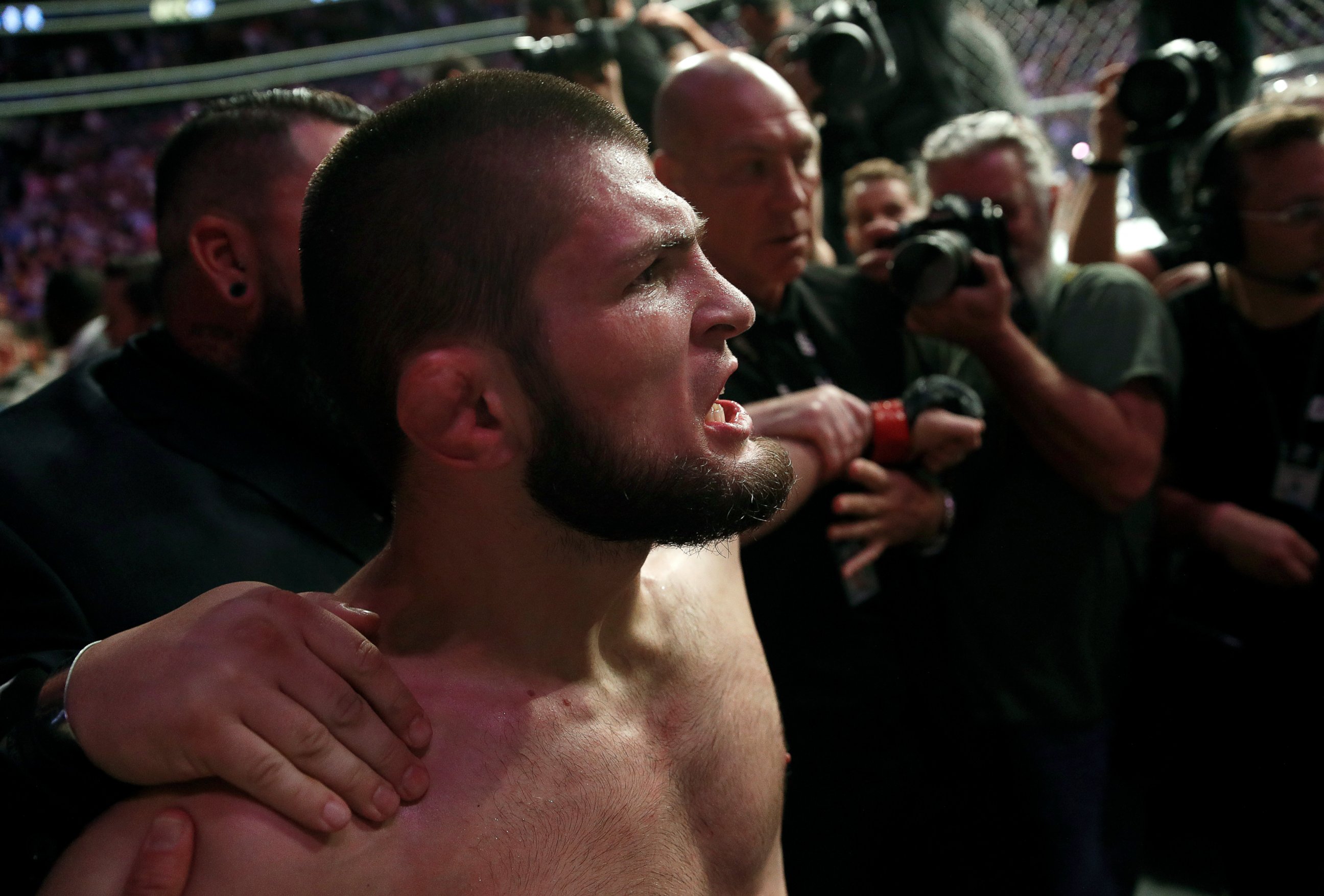 PHOTO: Khabib Nurmagomedov is held back outside of the cage after beating Conor McGregor in a lightweight title mixed martial arts bout at UFC 229 in Las Vegas, Saturday, Oct. 6, 2018. 