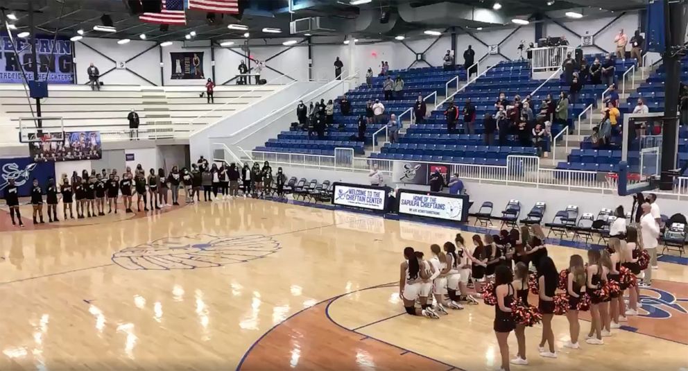 PHOTO: Players from Norman High School girls' basketball team in Norman, Okla., take a knee during the national anthem before a state quarterfinals game on March 11, 2021.
