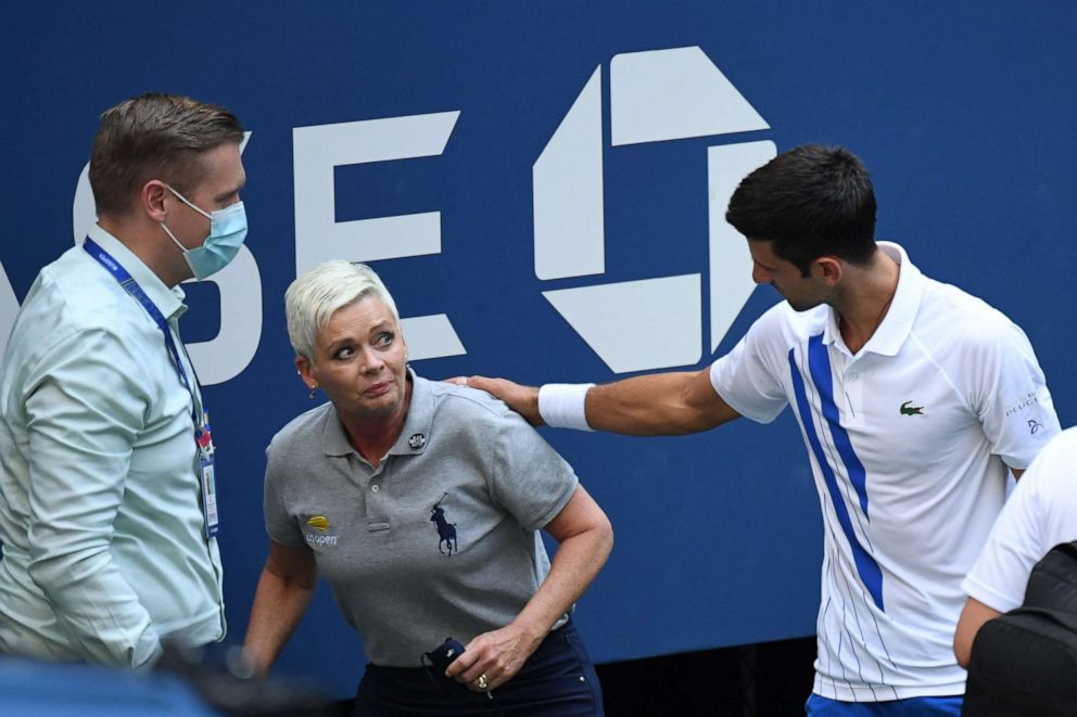 PHOTO: Novak Djokovic and a tournament official tend to a linesperson who was struck with a ball by Djokovic against Pablo Carreno Busta of Spain, Sept. 6, 2020, during the US Open in Queens, New York.
