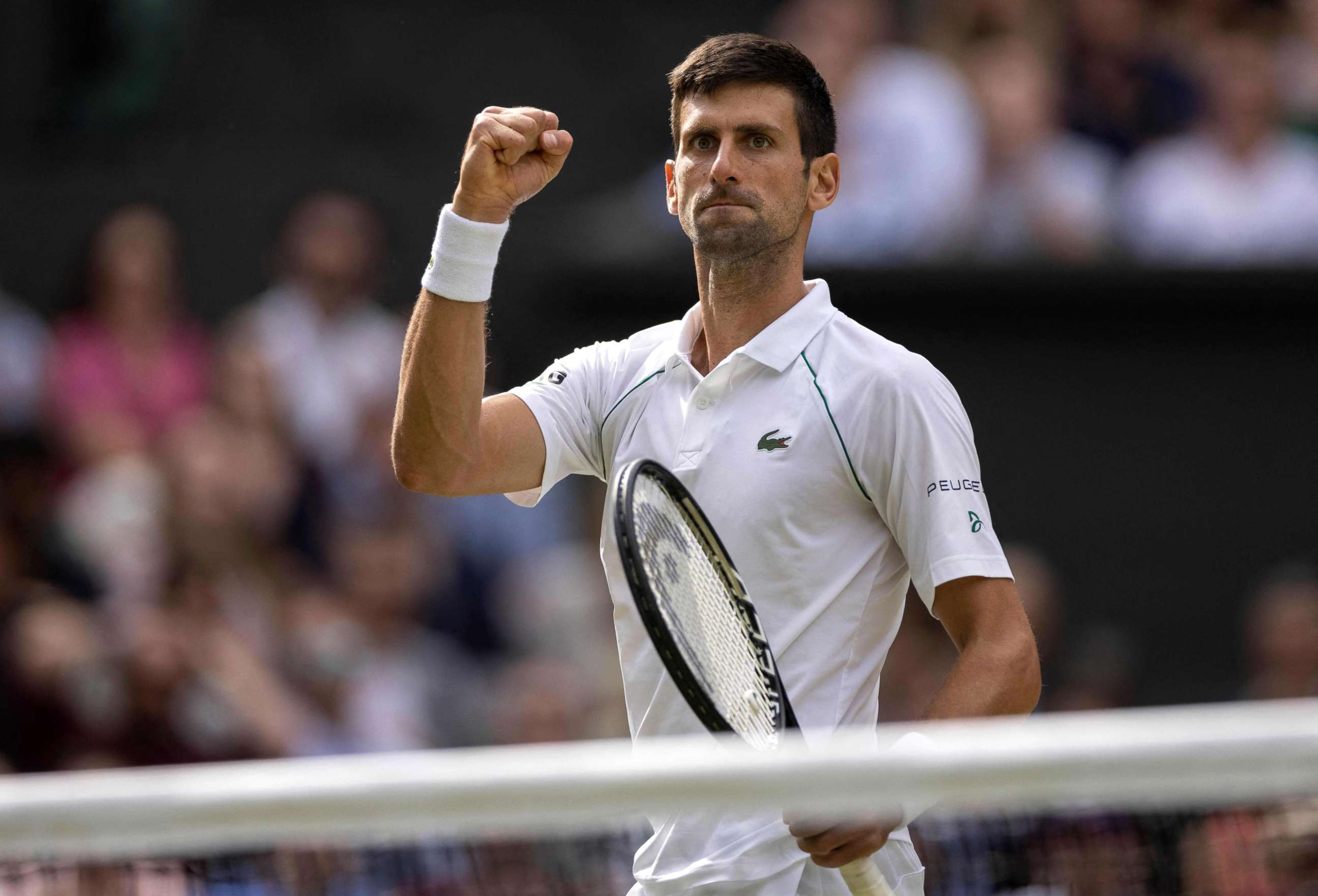 PHOTO: Novak Djokovic celebrates winning against Italy's Matteo Berrettini during their men's singles final match on the thirteenth day of the 2021 Wimbledon Championships at The All England Tennis Club in London, July 11, 2021.
