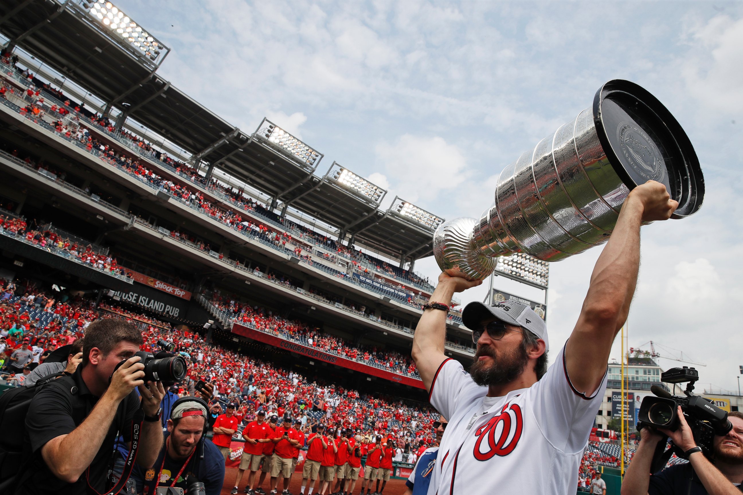 Washington Capitals' Alex Ovechkin, from Russia, lifts the Stanley Cup on the field before a baseball game between the Washington Nationals and the San Francisco Giants at Nationals Park, Saturday, June 9, 2018, in Washington.